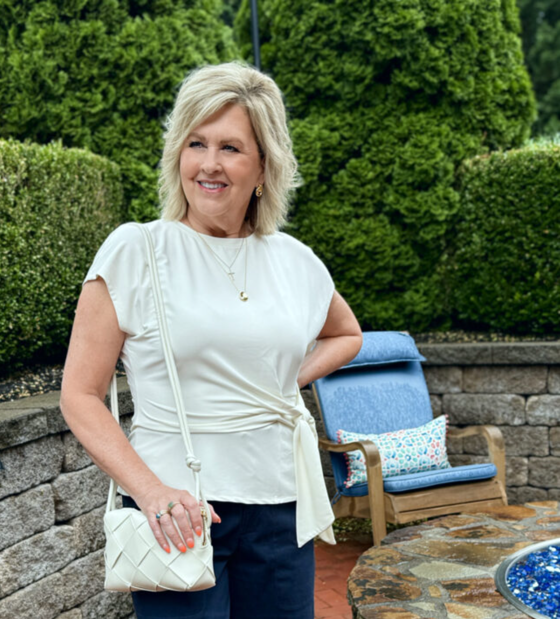 Woman over 50 in a cream tie-waist top 